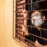 Man looking out the window during social isolation.