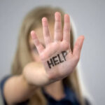 Help inscription on palm of sad little girl, protection of childrens rights