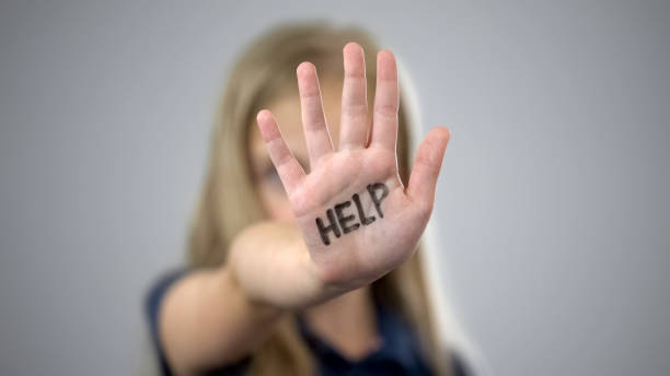 Help inscription on palm of sad little girl, protection of childrens rights