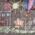 Kids are drawing on the sidewalk